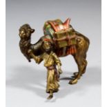 An early 20th Century Austrian cold painted bronze figure leading a laden camel, 3ins high x 3.25ins