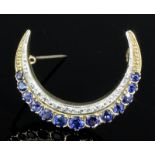 A modern gold coloured metal mounted sapphire and diamond set crescent pattern brooch, the face