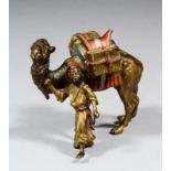 An early 20th Century Austrian cold painted bronze figure leading a laden camel, 3ins high x 3.25ins