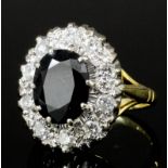 A modern 18ct white and yellow gold mounted sapphire and diamond set ring, the oval cut sapphire