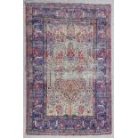 An antique Kashan rug woven in colours with "Tree of Life" motifs on an ivory ground within