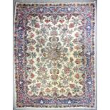 An antique Kirman carpet, the cut pile woven in pinks, blues and other colours with central double