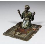 A late 19th/early 20th Century Austrian cold painted bronze figure of a praying Arab on a carpet