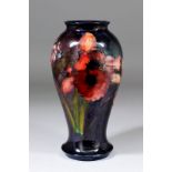 A Moorcroft pottery baluster shaped vase, tube lined with "Orchid" design under a rich flambe glaze,