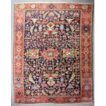 An antique Karajar carpet woven in colours with all-over stylised floral repeats on a dark blue