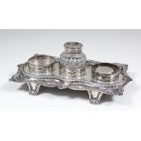 A George III silver rectangular inkstand of shaped outline with bold gadroon and leaf mounts to rim,