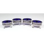 A set of four George III oval salts, the pierced sides with bead mounts to rim and each on four claw