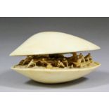 A Japanese ivory okimono carved as a shell, the interior with fishermen in boats and on the beach,