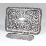 An Edward VII silver rectangular dressing table tray boldly embossed with floral and leaf scroll