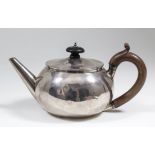 A George III plain silver circular teapot of squat bulbous form, with turned wood finial and C-