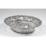 An Edward VII silver oval basket of Art Nouveau design, the shaped and pierced rim cast with flowers