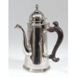 A good Queen Anne plain silver chocolate pot with domed cover and folding turned top finial, moulded