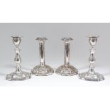 A pair of Edward VII silver pillar candlesticks with oval sconces and baluster shaped stems, on