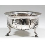 A George III Irish silver circular sugar bowl with partly fluted body, on three shell supports