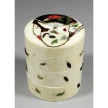 A Japanese ivory and shibyama circular three tiered box and cover inset with carved hardstone and