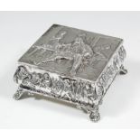 A late Victorian silver square trinket box, the lid embossed with figures in a tavern, the sides