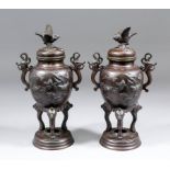 A pair of Japanese brown patinated bronze two handled urns and covers, each 9ins (232mm) high  (lids