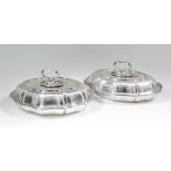 A pair of George V silver oval entree dishes and covers with shaped and moulded mounts to rims and