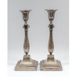 A pair of George V silver pillar candlesticks of Neo-classical design with square section baluster