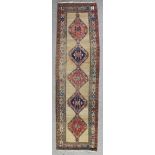 An antique Sarab runner, woven in colours with five lozenge shaped medallions on a tan ground,