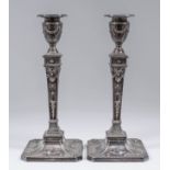 A pair of Edward VII silver pillar candlesticks of Neo-classical design with urn pattern sconces and