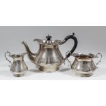 A George V silver Harlequin three piece tea service of baluster shape with shaped rims and scroll