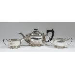 A George V silver three piece tea service of octagonal panelled form with angular handles and on