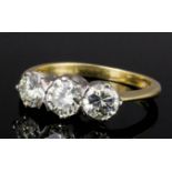 An 18ct white and yellow gold mounted three stone diamond ring, the central old cut stone