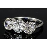 An early 20th Century silvery coloured metal mounted three stone diamond ring, the central old cut