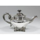 An early Victorian silver circular teapot with floral and leaf cast finial, reeded scroll handle and