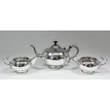 A 20th Century Indian silvery metal three piece tea service with shaped footrims, the teapot with