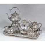 A Victorian plated tea service, the sides raised with foliage and scrolls, comprising kettle and