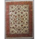 A Tabriz carpet, woven in colours with scrolled floral repeat, on an off white ground, within