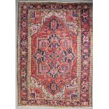 An antique Heriz carpet, woven in colours with central star shaped medallion and conforming