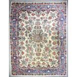An antique Kirman carpet, the cut pile woven in pinks, blues and other colours with central double