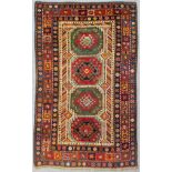 A South Caucasian rug woven in colours with four hooked motifs on alternate coloured grounds and