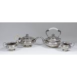 An Edward VII silver Harlequin four piece tea service with shaped, scroll and gadroon cast mounts,