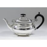 A George V silver rectangular teapot of Georgian design, the squat bulbous body with slightly