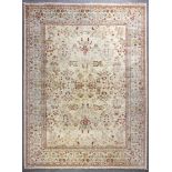 A modern Meshad carpet, woven in muted colours with all over floral motifs on a pale fawn ground,