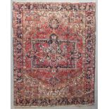 A Heriz carpet woven in colours with central star shaped double headed medallion, spandrels and