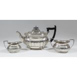 A George IV silver teapot of Georgian design, with partly fluted body on four ball feet by