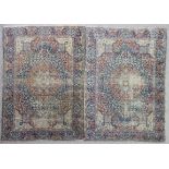 A pair of Tabriz rugs, woven in muted colours with oval double headed medallions, conforming