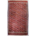 An antique Yomut turkman carpet woven in muted colours and ivory with endless repeat of lozenge