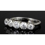 A 1920s platinum mounted five stone diamond ring, the central old cut stone approximately .30ct