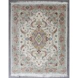 A modern Tabriz silk rug woven in colours with oval double headed medallion, conforming spandrals