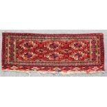 A Tekke Turkmen Torba, woven in muted colours with endless repeat of six guls on a madder ground,