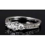 A modern 18ct white gold and platinum mounted three stone diamond ring, the shoulders set with