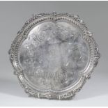 A Victorian silver circular salver with shaped rim, leaf and bead mounts and engraved to centre with