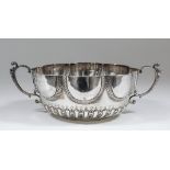 A George III silver circular two handled bowl with lobed sides, gadrooned and spiraled fluted