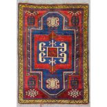 A Farchalou Kazak rug woven in red and white with geometric double headed medallion on a blue